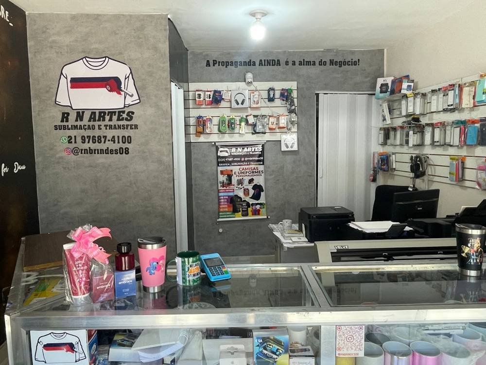 Balcão da RN Artes com canecas, copos personalizados e o logo da marca na parede